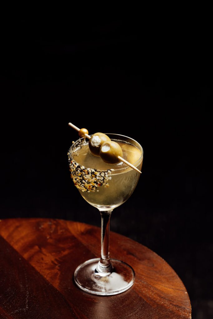The “Holy Water” drink, made with Cream Cheese-Washed Ketel One Vodka, Everything Bagel Seasoning, Dolin Dry, and House Olive Brine
