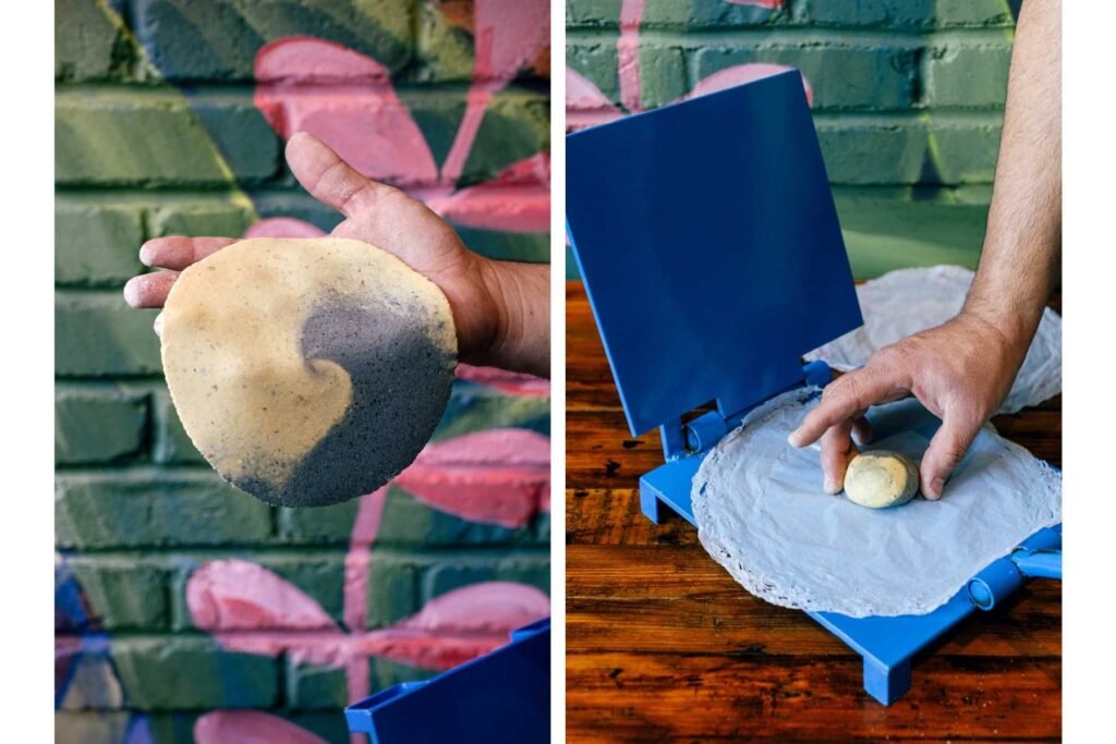 The pressing of a yellow and blue corn tortilla.